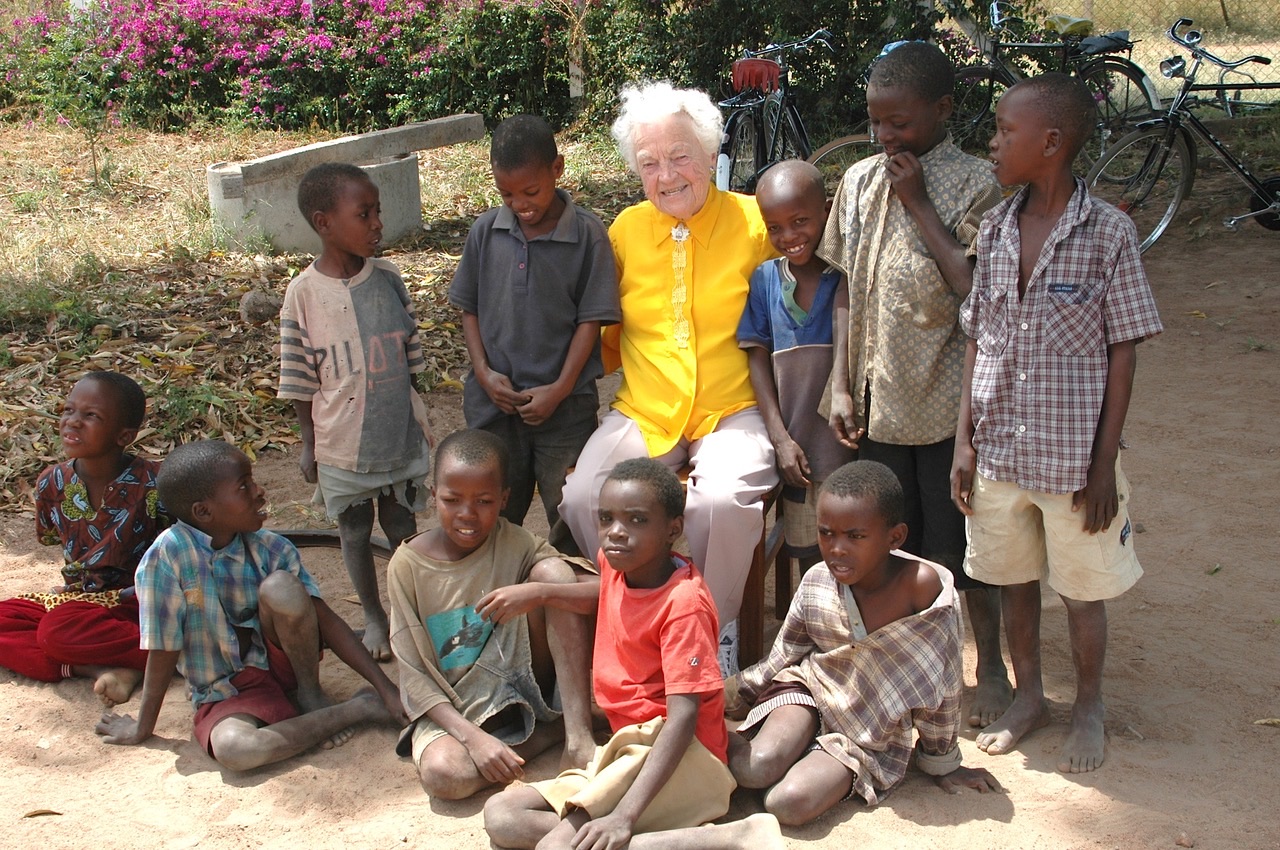 Hazel McCallion seated outdoors surrounded by a group of children.